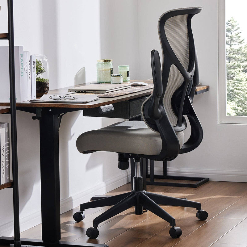 Modern office chair in front of a desk with a window in the background
