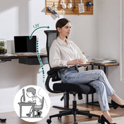 Woman sitting at a desk with a black office chair, demonstrating ergonomic posture.