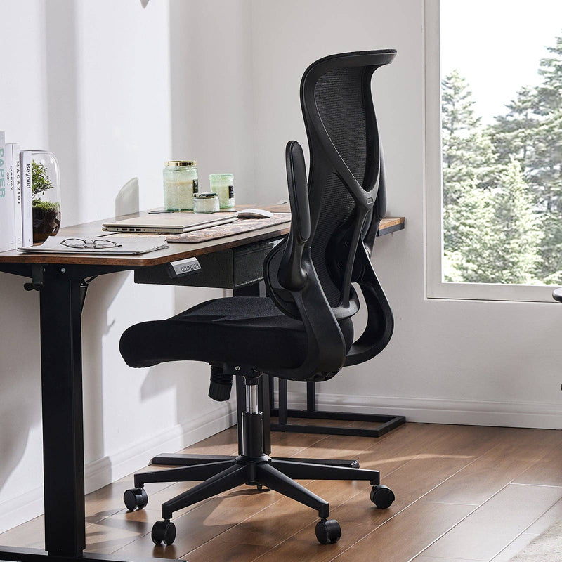 Black office chair in front of a desk with a window in the background