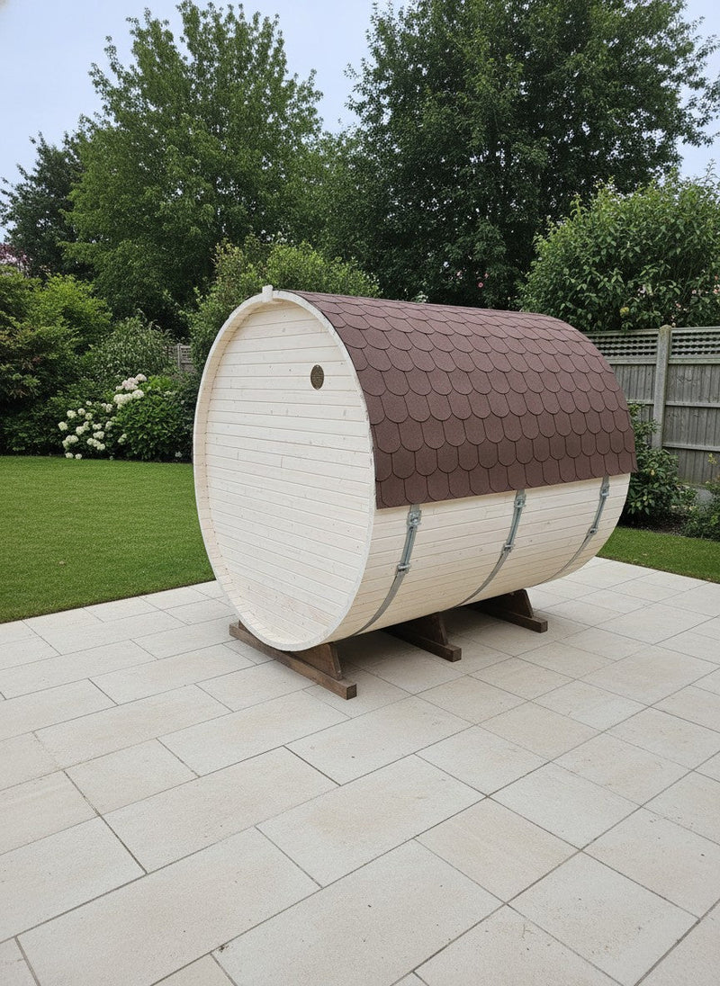  barrel-shaped outdoor sauna with brown roof and white body on a patio