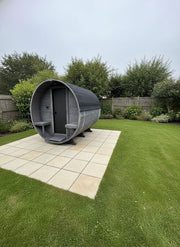 Outdoor pod structure in a garden setting with grass and trees in the background